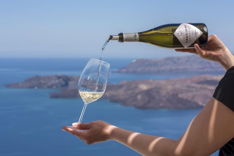A man pours white wine, golden nectar cascading into a glass. Anticipation and elegance blend, setting the stage for an exquisite experience.